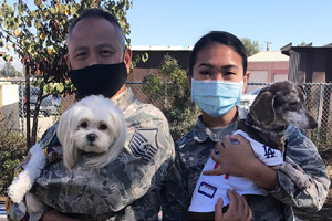 Photograph of Thomas, Suede, and Cookie visit National Guard dog